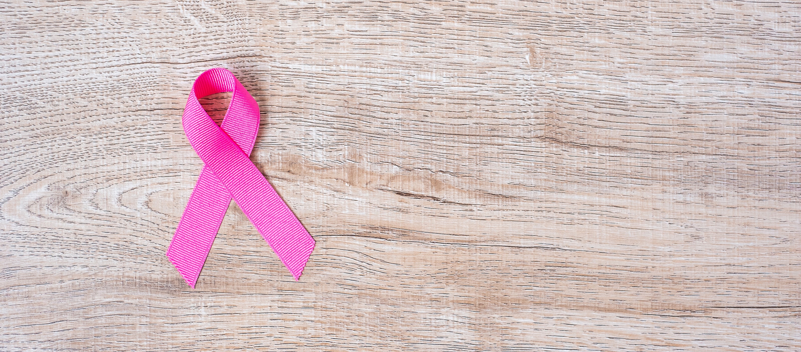 Pink ribbon on a wooden surface